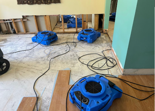 Industrial air movers drying water-damaged room
